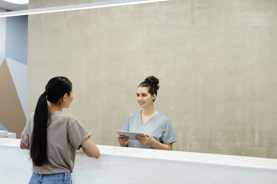 A welcoming team member greeting a student at a front desk