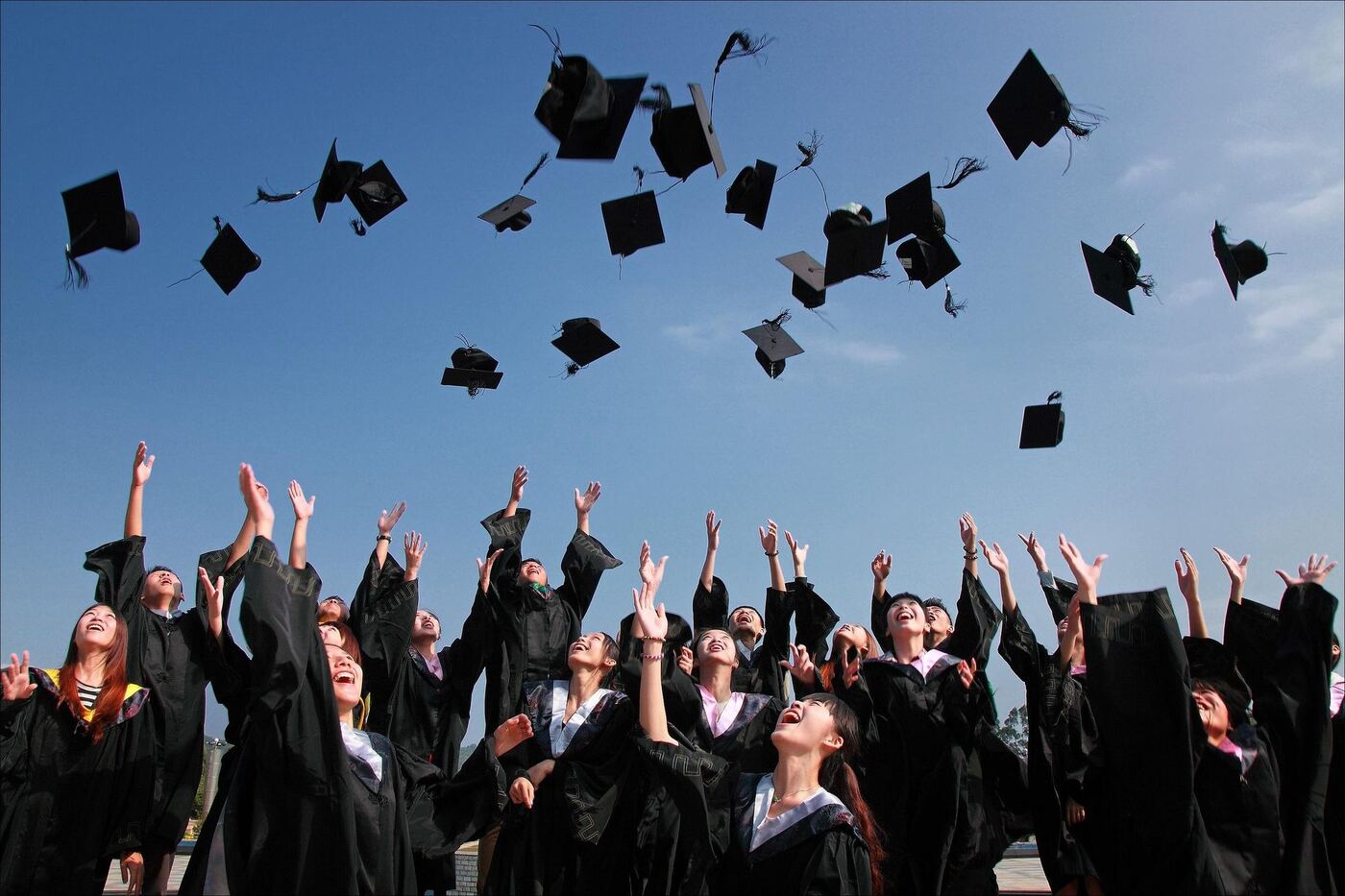 Graduates celebrating and throwing their caps