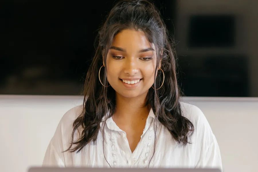 A smiling student working on a laptop